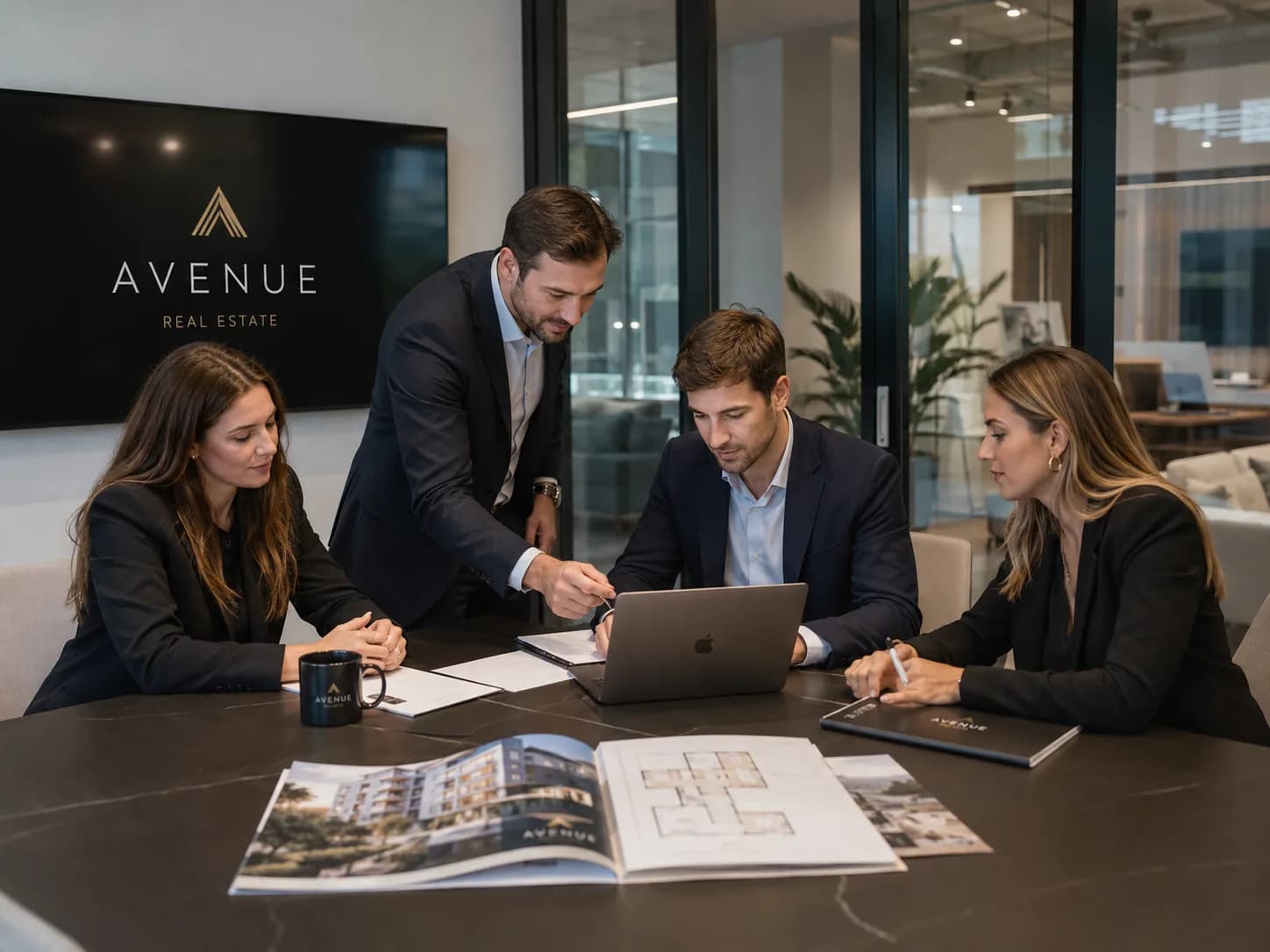 Equipo inmobiliario revisando propiedades y documentación en una oficina profesional.